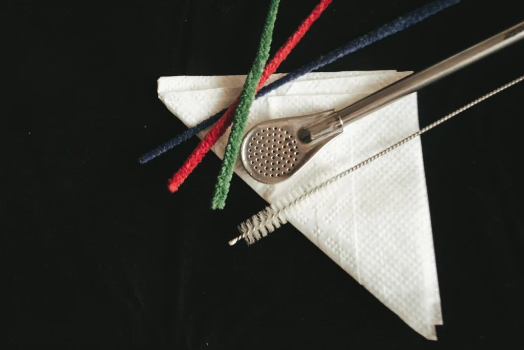 A bombilla and cleaning brushes placed on top of a napkin.